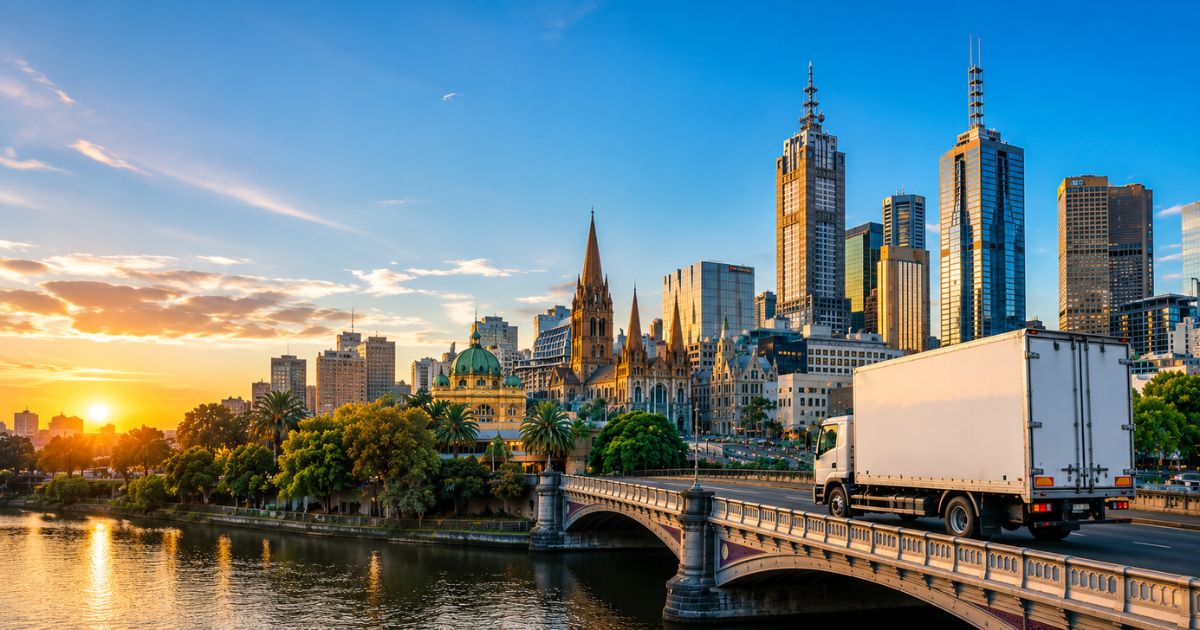 Professional interstate removalist truck driving across a bridge into Melbourne city
